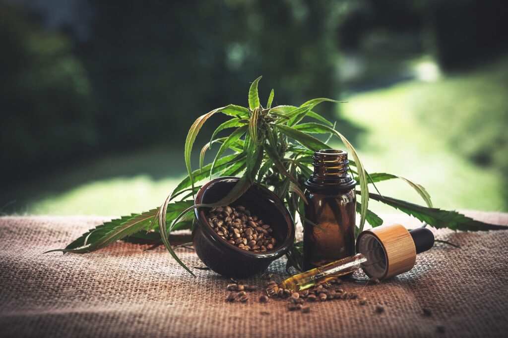CBD oil bottle beside a hemp leaf